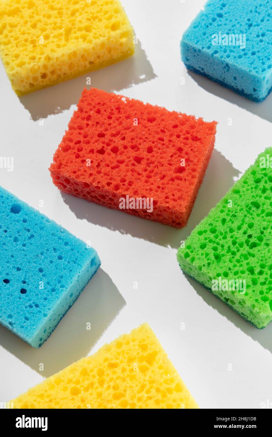 Motif avec éponges colorées pour laver la vaisselle sur fond blanc Banque D'Images