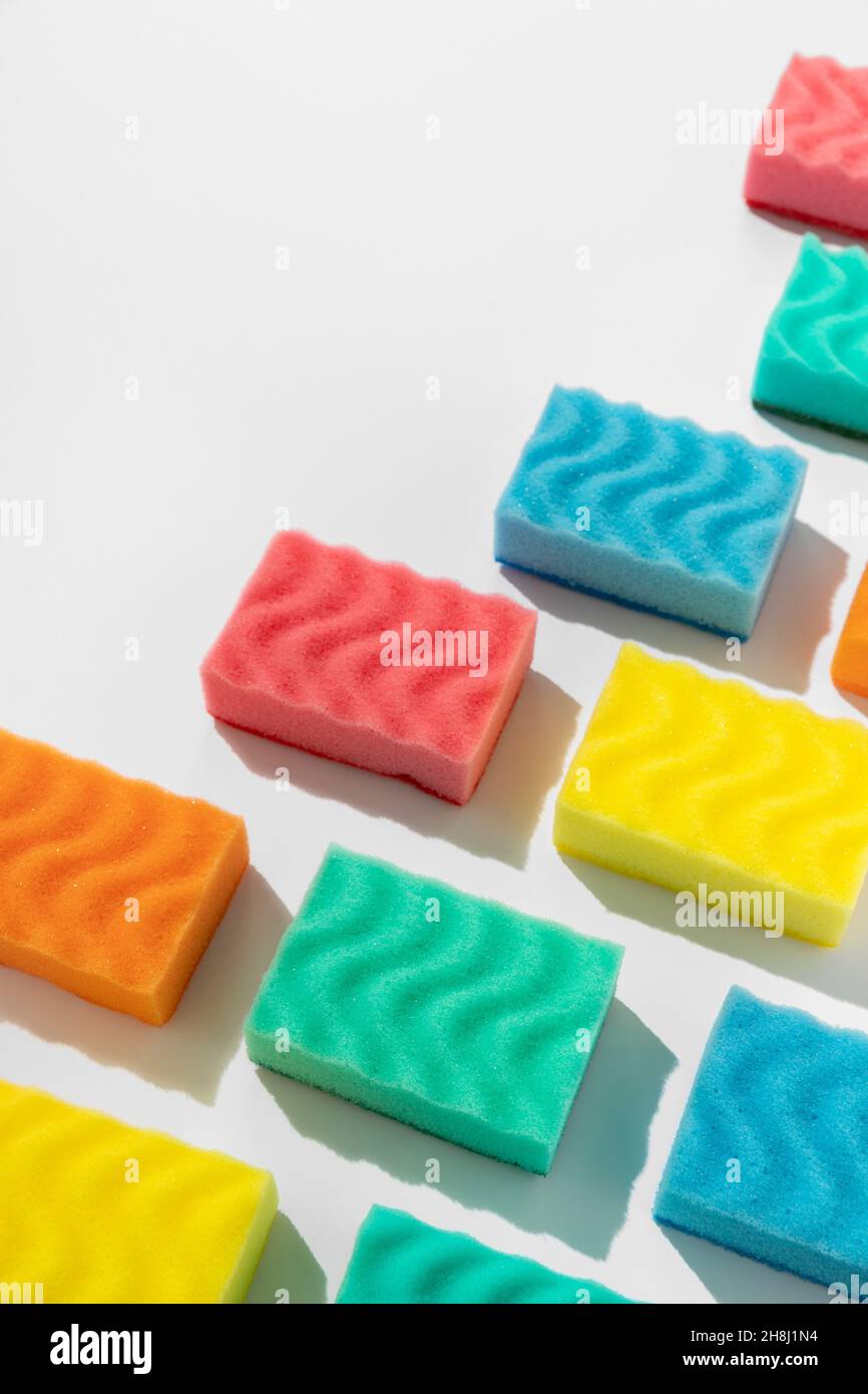 Motif avec éponges colorées pour laver la vaisselle sur fond blanc Banque D'Images