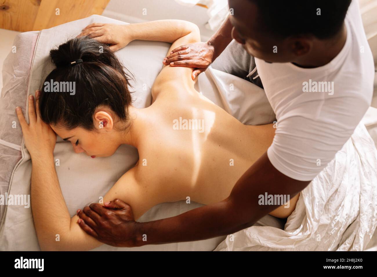 Mains d'un thérapeute professionnel afro-américain qui donne un massage du dos Banque D'Images