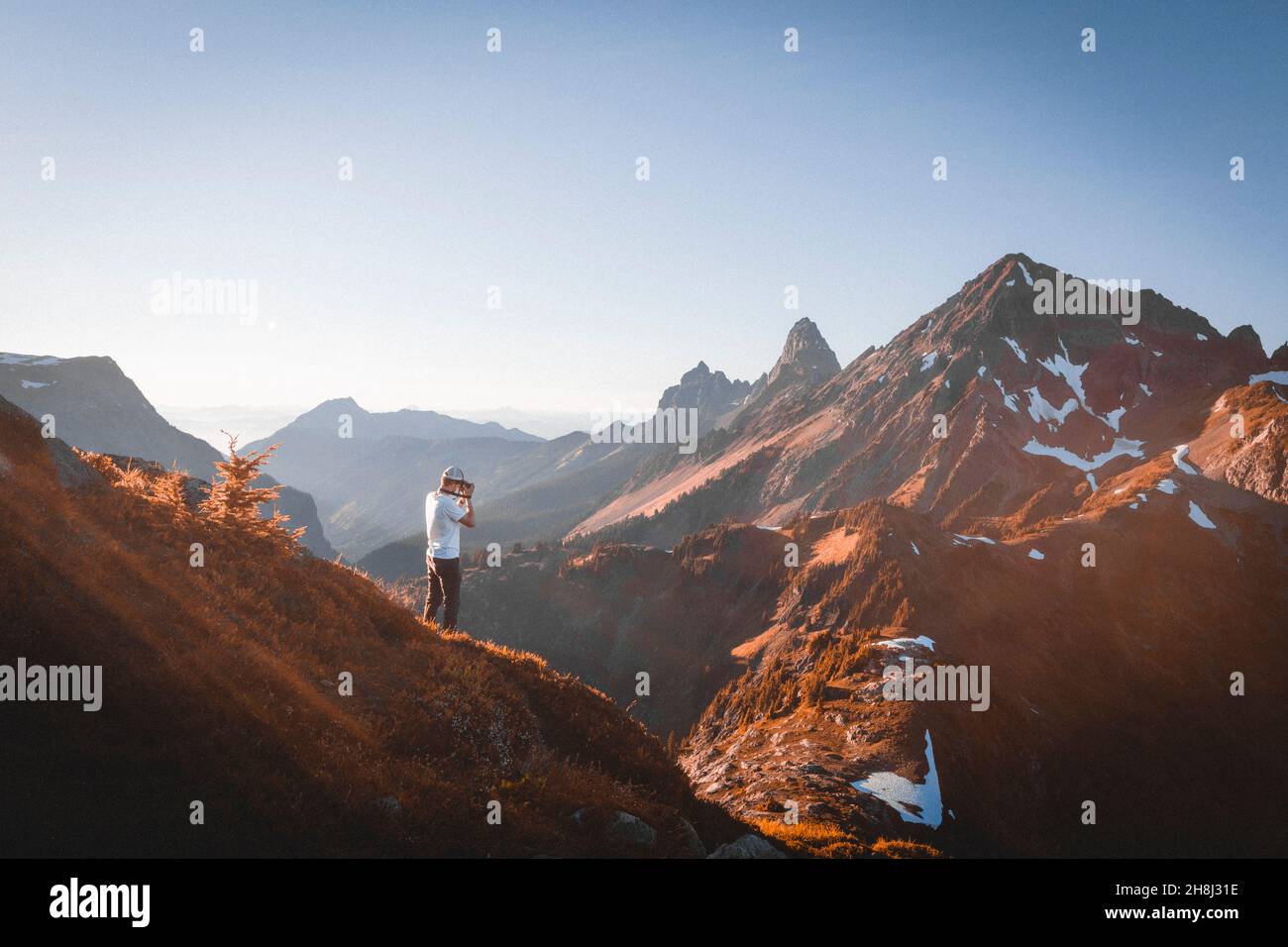 Un homme avec un appareil photo prenant des photos de montagnes dans le nord de Cascades Banque D'Images