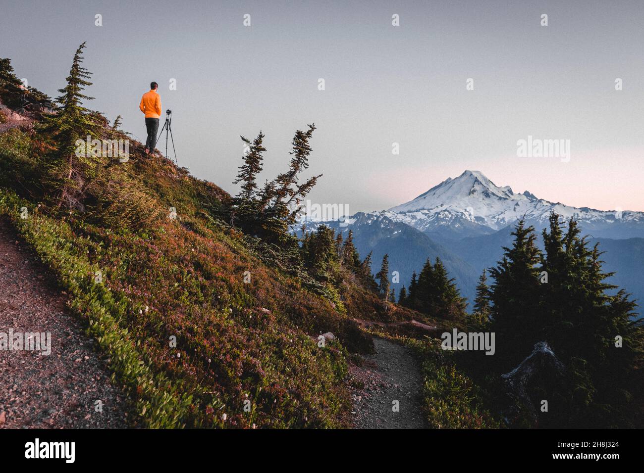 Un homme avec un appareil photo prend des photos de montagnes dans le nord de Cascades Banque D'Images