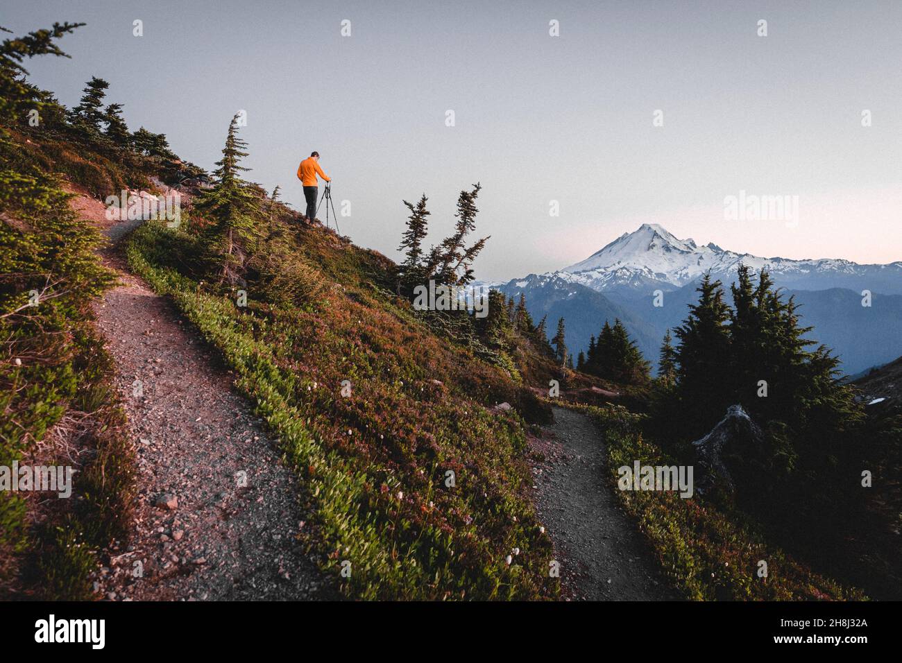 Un homme avec un appareil photo prend des photos de montagnes dans le nord de Cascades Banque D'Images