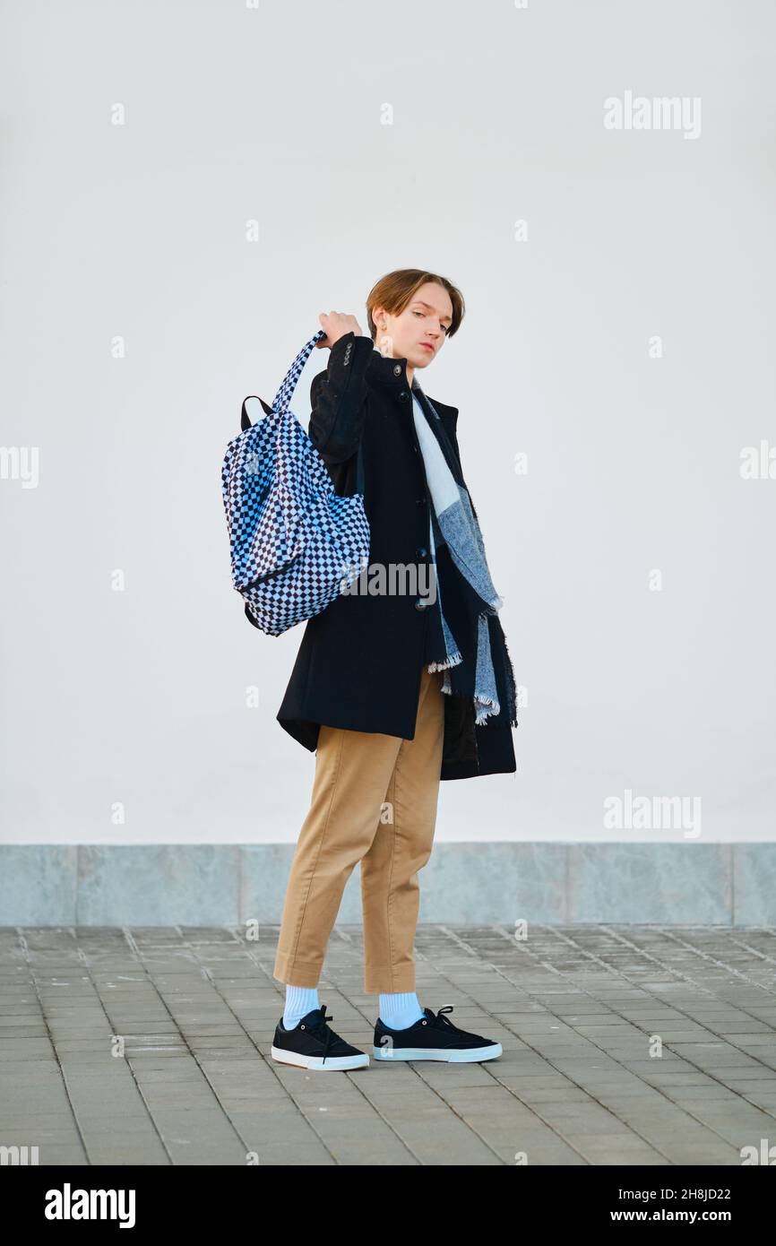 Portrait complet du jeune étudiant avec sac à dos en laine vierge manteau, écharpe et pantalon court extérieur Banque D'Images