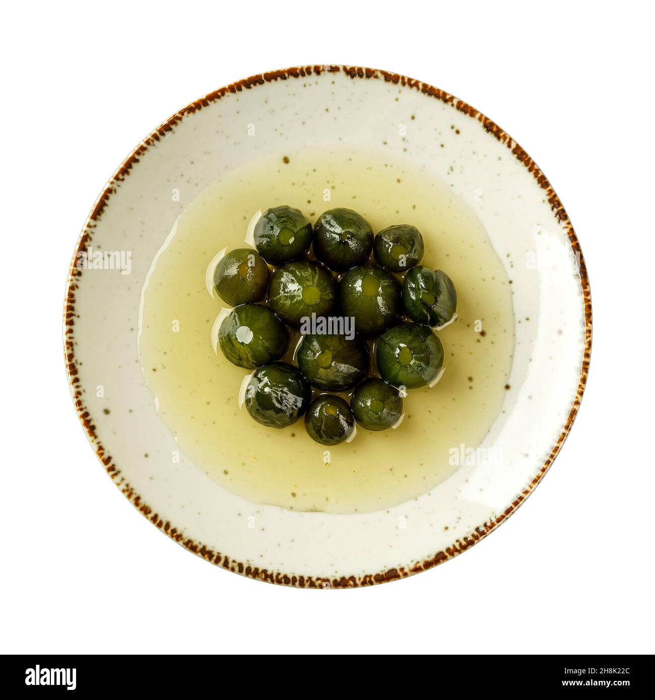 Délicieuses figues entières non mûres au sirop sur une assiette en porcelaine blanche isolée sur un fond blanc.Confiture de figues verte savoureuse.Dessert méditerranéen traditionnel Banque D'Images