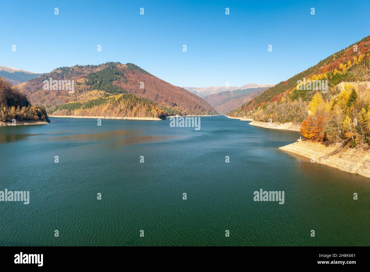 Belle vue sur un lac avec colline dans le fond couvert par des arbres dans les couleurs d'automne en Roumanie Banque D'Images