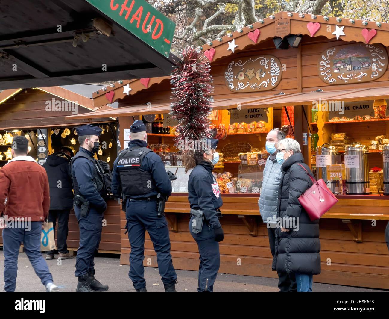 Surveillance de la police les personnes portant un masque respiratoire de sécurité devant les étals du marché Banque D'Images