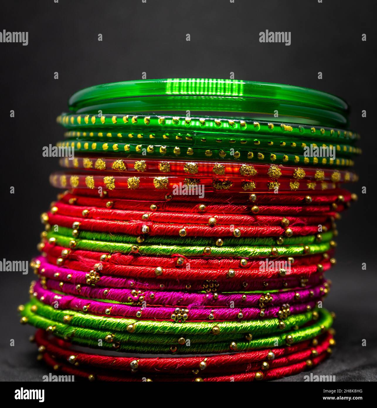 Gros plan de bracelets colorés (bracelets) avec des points dorés sur une surface grise Banque D'Images