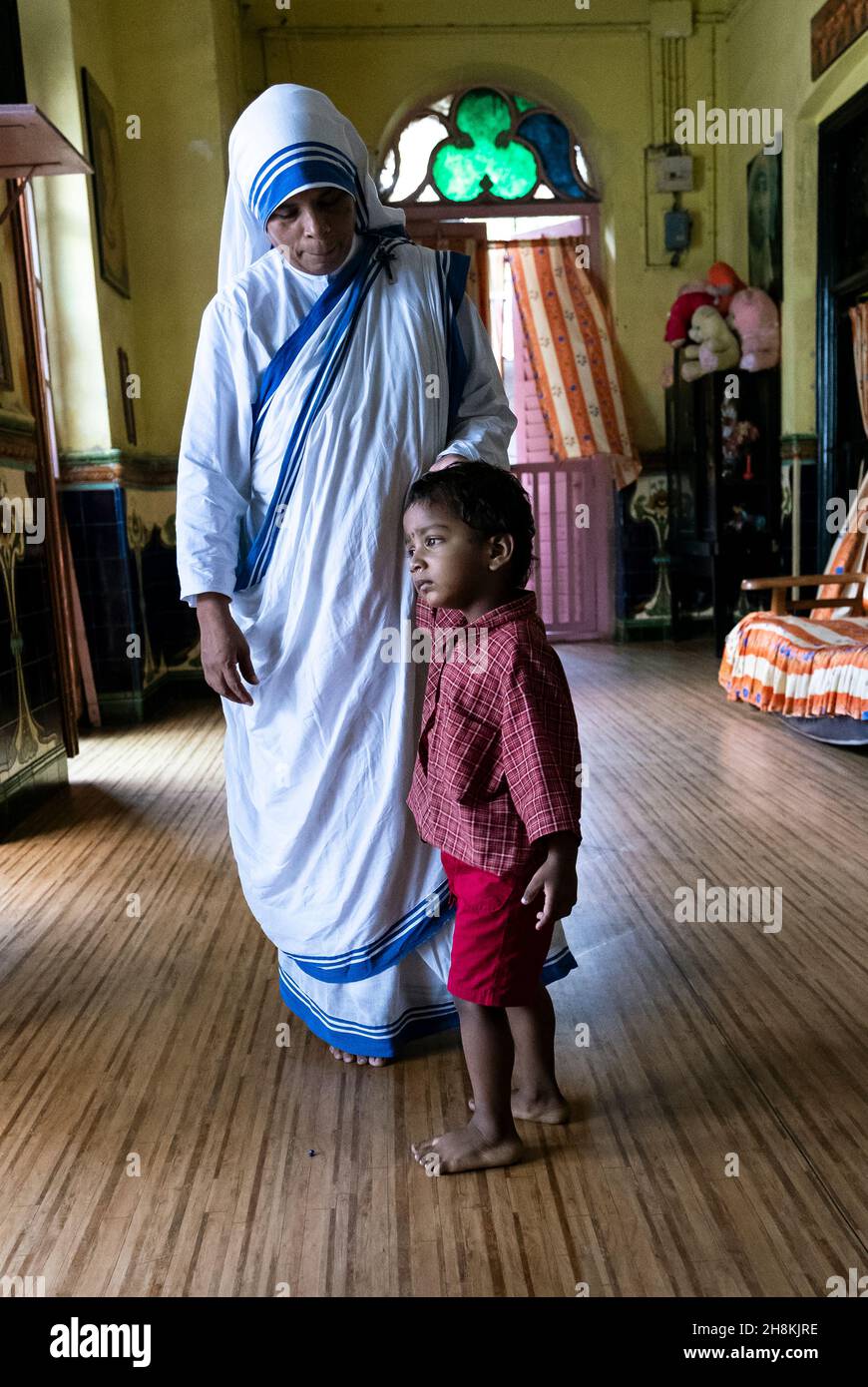 Mère Teresa sœur tenant la main d'un jeune garçon à la maison dirigée par les Missionnaires de la Charité Banque D'Images