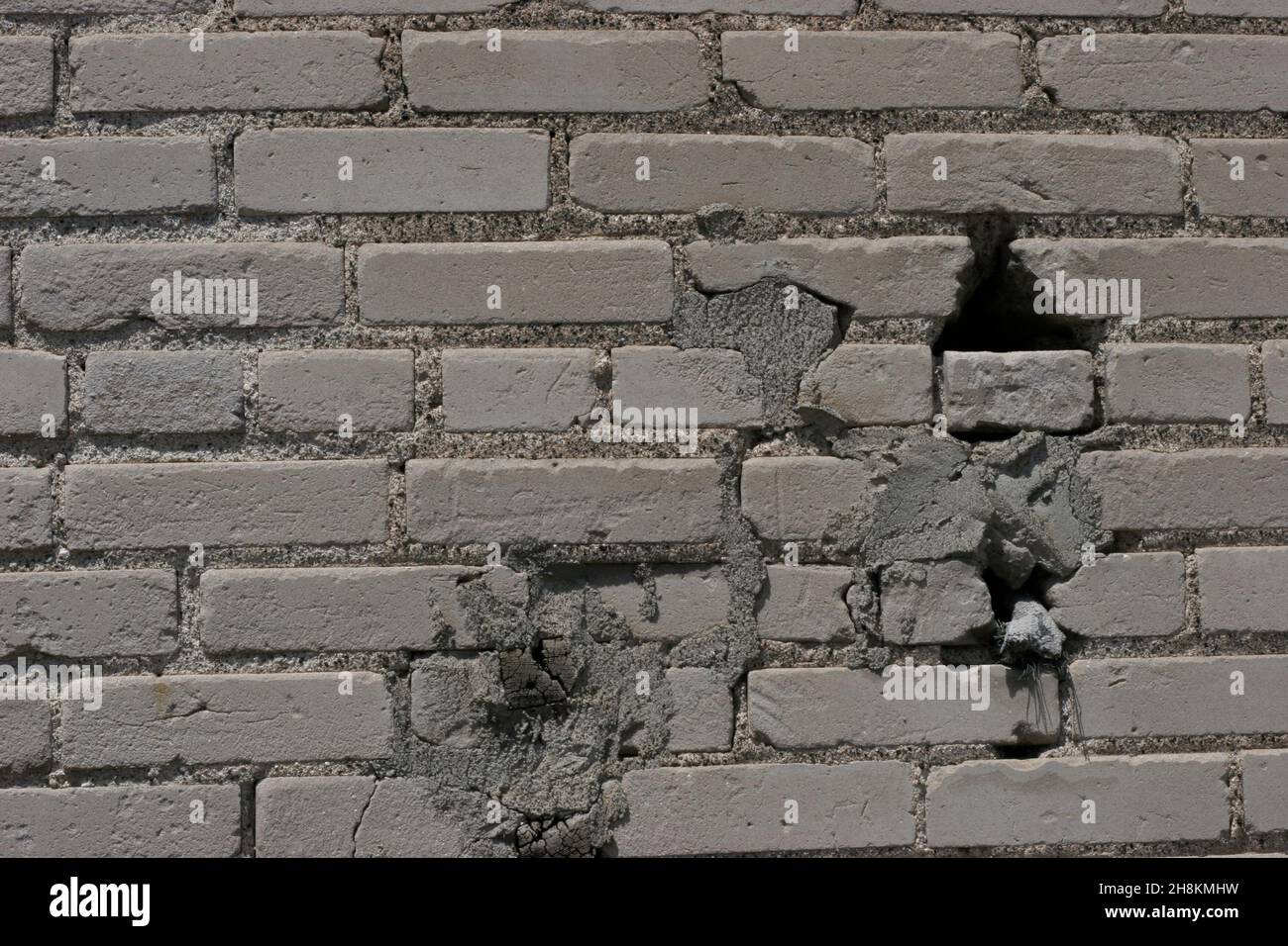 Mur en pierre d'époque avec des abrasions légères, des fissures et des trous où la brique s'est détériorée Banque D'Images