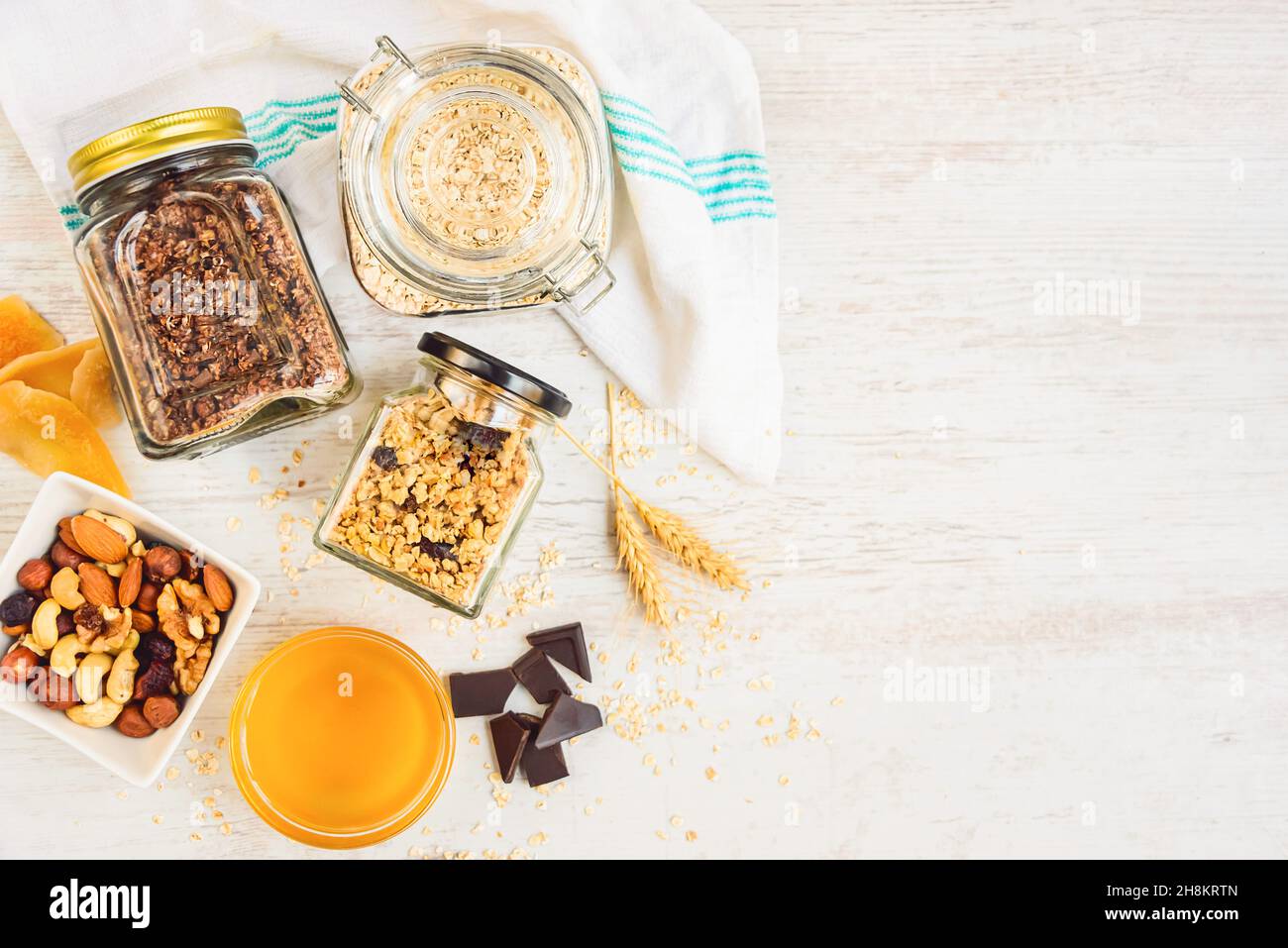 Vue de dessus des bocaux pleins d'avoine et divers granola croquant - nature, fruits secs, noix et chocolat.Concept de repas de grande qualité.Copier l'espace. Banque D'Images