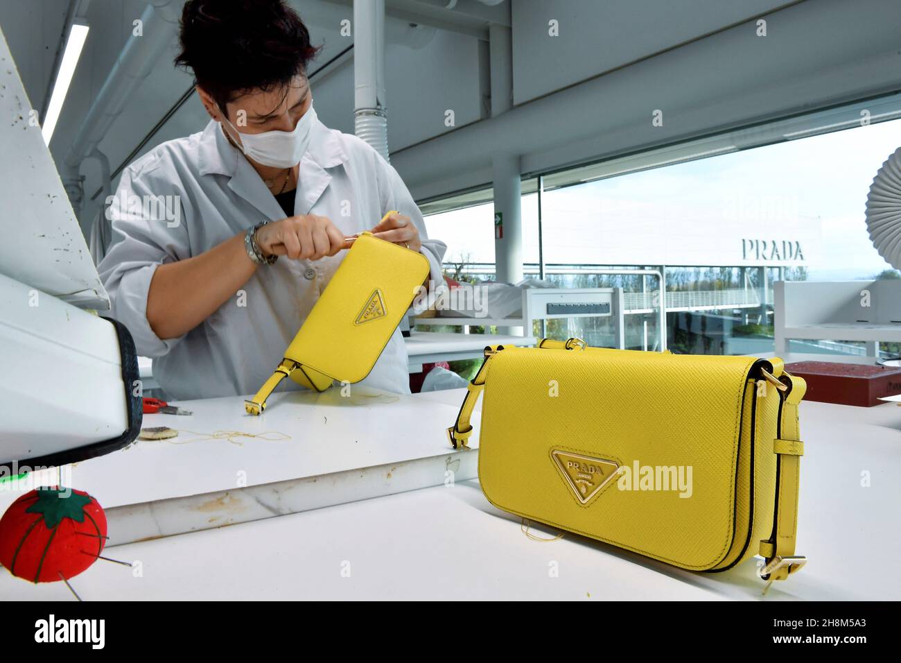 Un membre du personnel travaille sur un sac Prada fait main à l'usine de  jardins du siège industriel du designer italien qui accueille la production  et le développement des collections de produits
