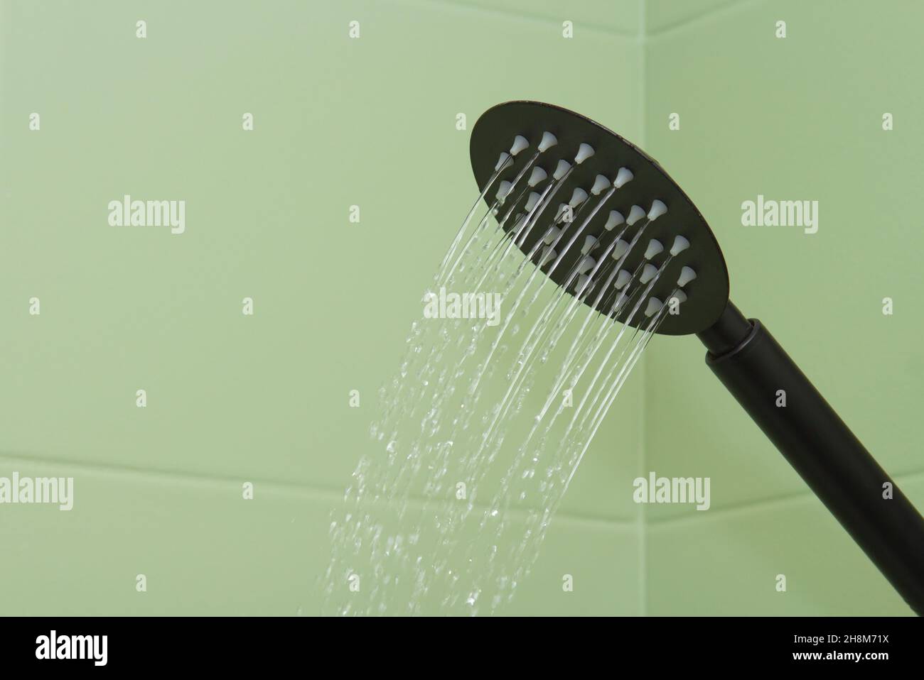 Gros plan sur les écoulements d'eau d'un arrosoir noir. Banque D'Images