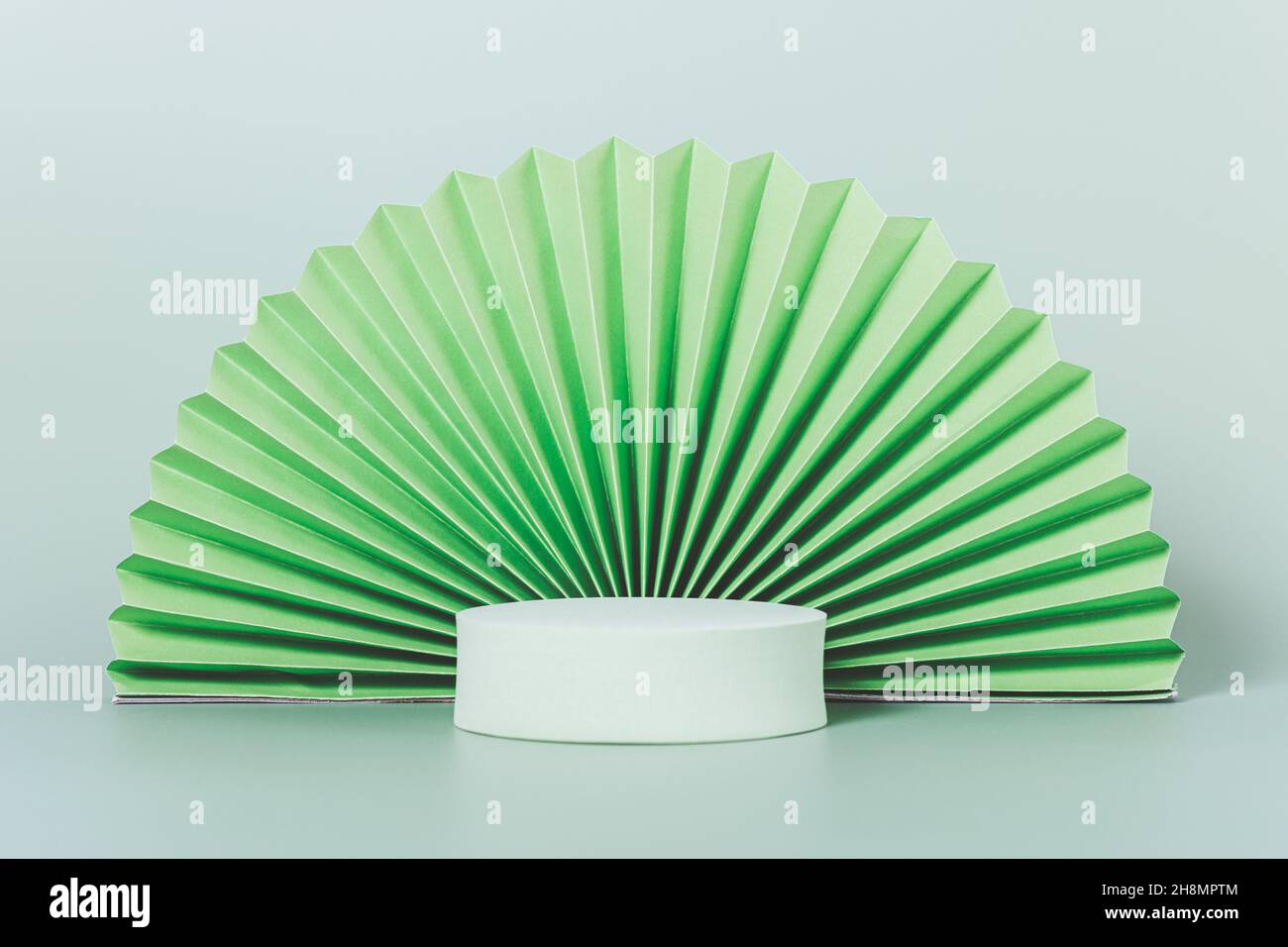 Socle rond avec ventilateur en papier origami sur fond vert clair, modèle  pour la présentation du produit Photo Stock - Alamy