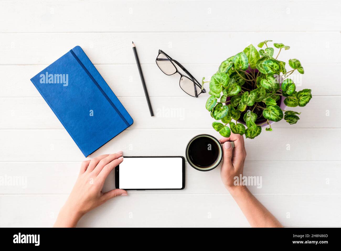 Vue de dessus d'une fille utilisant un smartphone au lieu de travail Banque D'Images