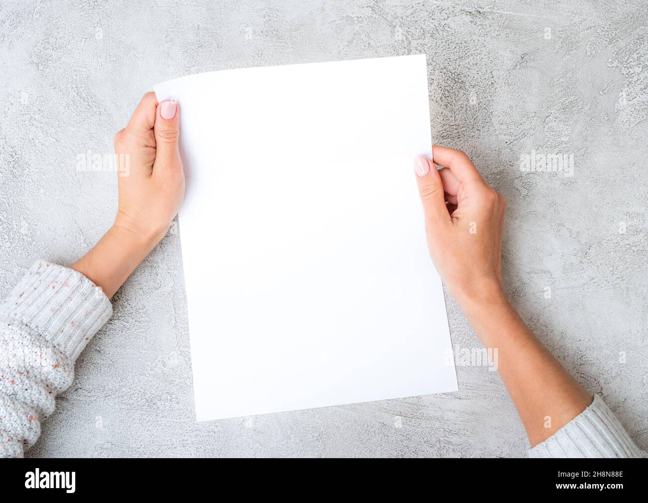 Mains de fille tenant une feuille de papier Banque D'Images