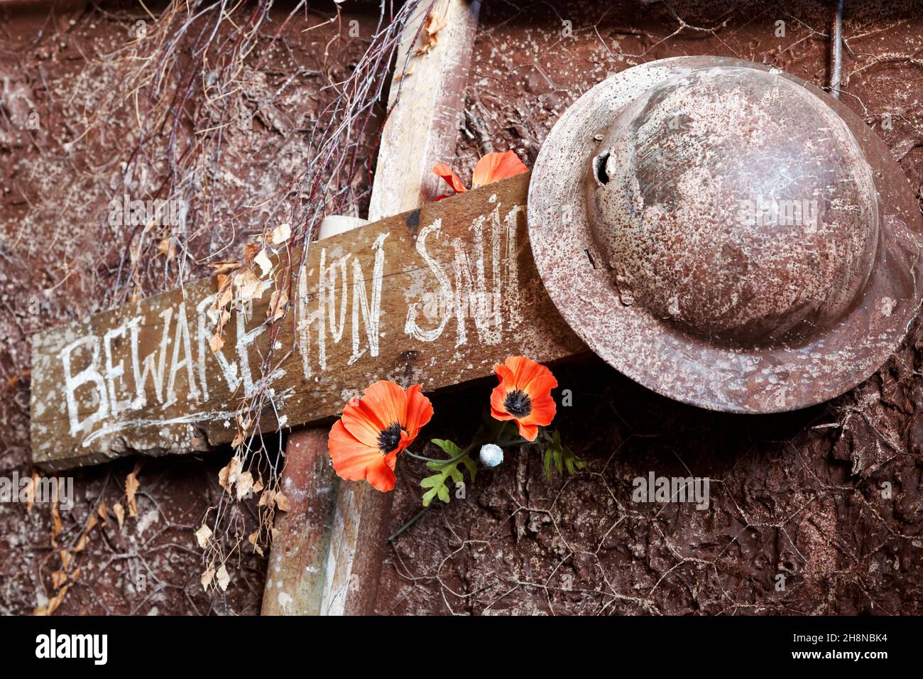 Scène de tranchée britannique WW1 avec casque en étain et coquelicots sur un panneau en bois.(Attention, Hun Sniper) Banque D'Images