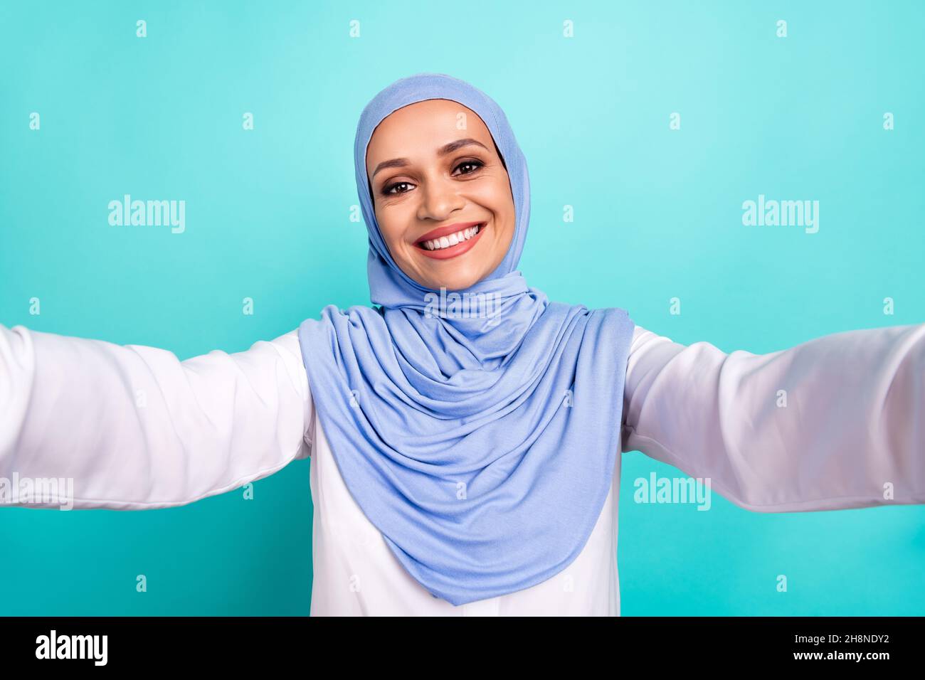 Photo de douce charmante jeune femme porter un foulard arabe enregistrement  vidéo sourire isolé couleur turquoise arrière-plan Photo Stock - Alamy