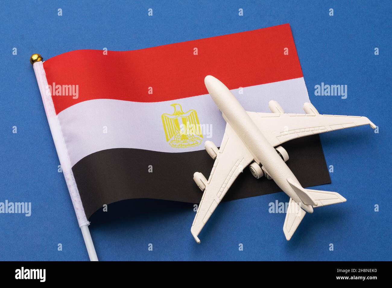 Drapeau de l'Égypte et avion jouet sur fond bleu, concept de vol vers l'Égypte, vue de dessus Banque D'Images