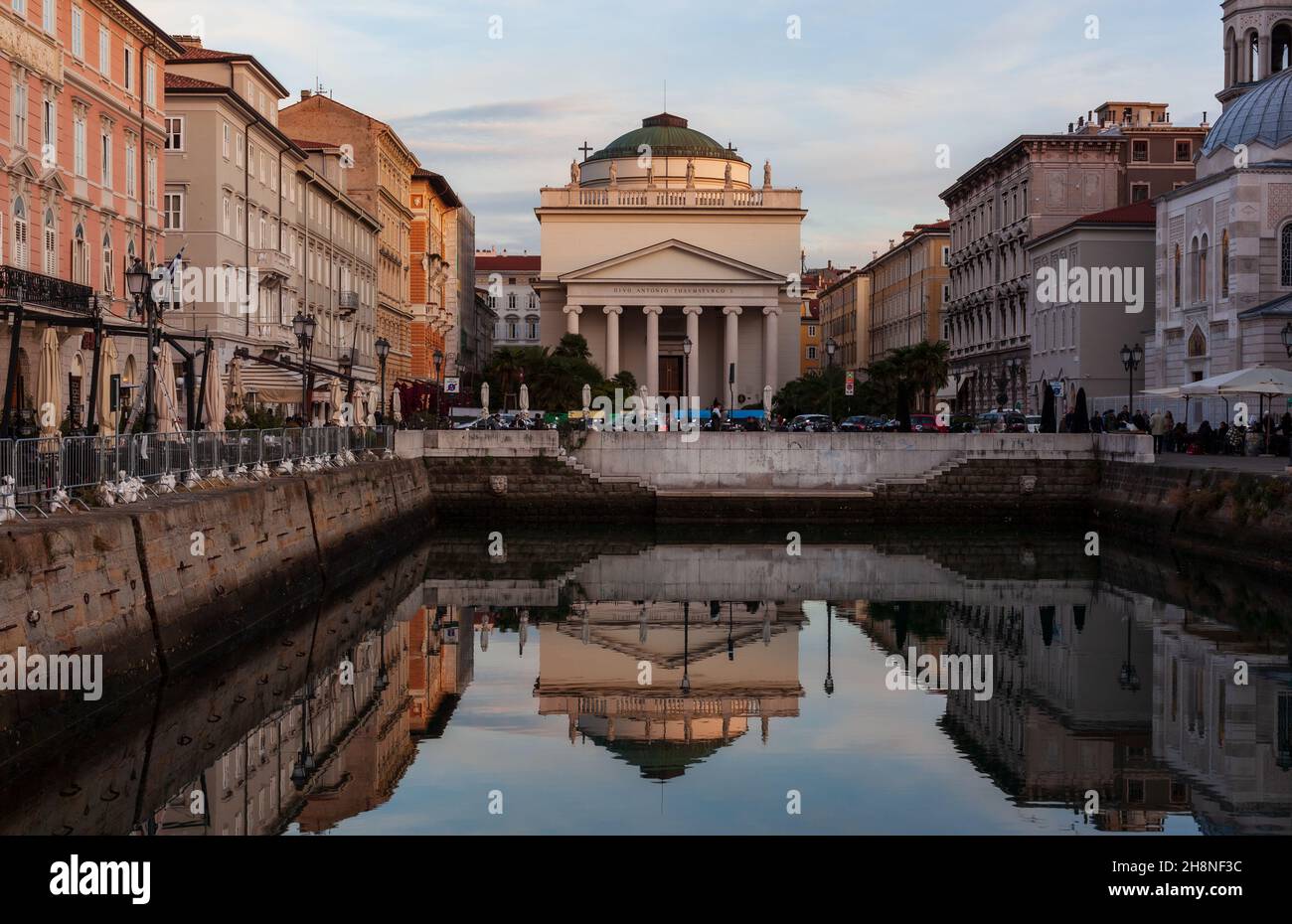 Vue panoramique sur la Gran Canale à Trieste au coucher du soleil.L'église de Saint-Antonio Thaumaturgo se reflète sur l'eau du Grand Canal Banque D'Images