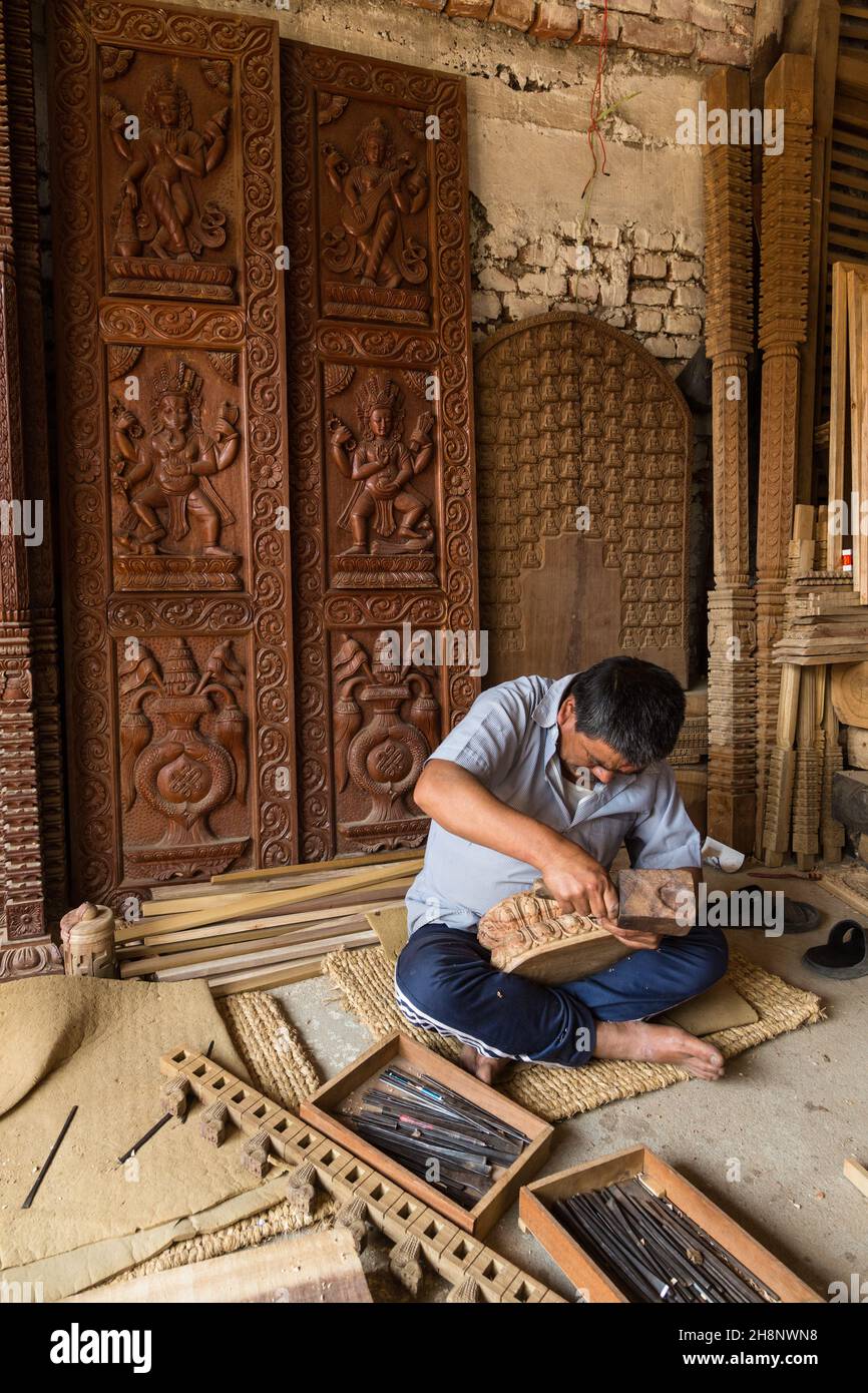 Un népalais faisant une sculpture en bois dans son atelier dans le village médiéval de Bungamati, au Népal. Banque D'Images