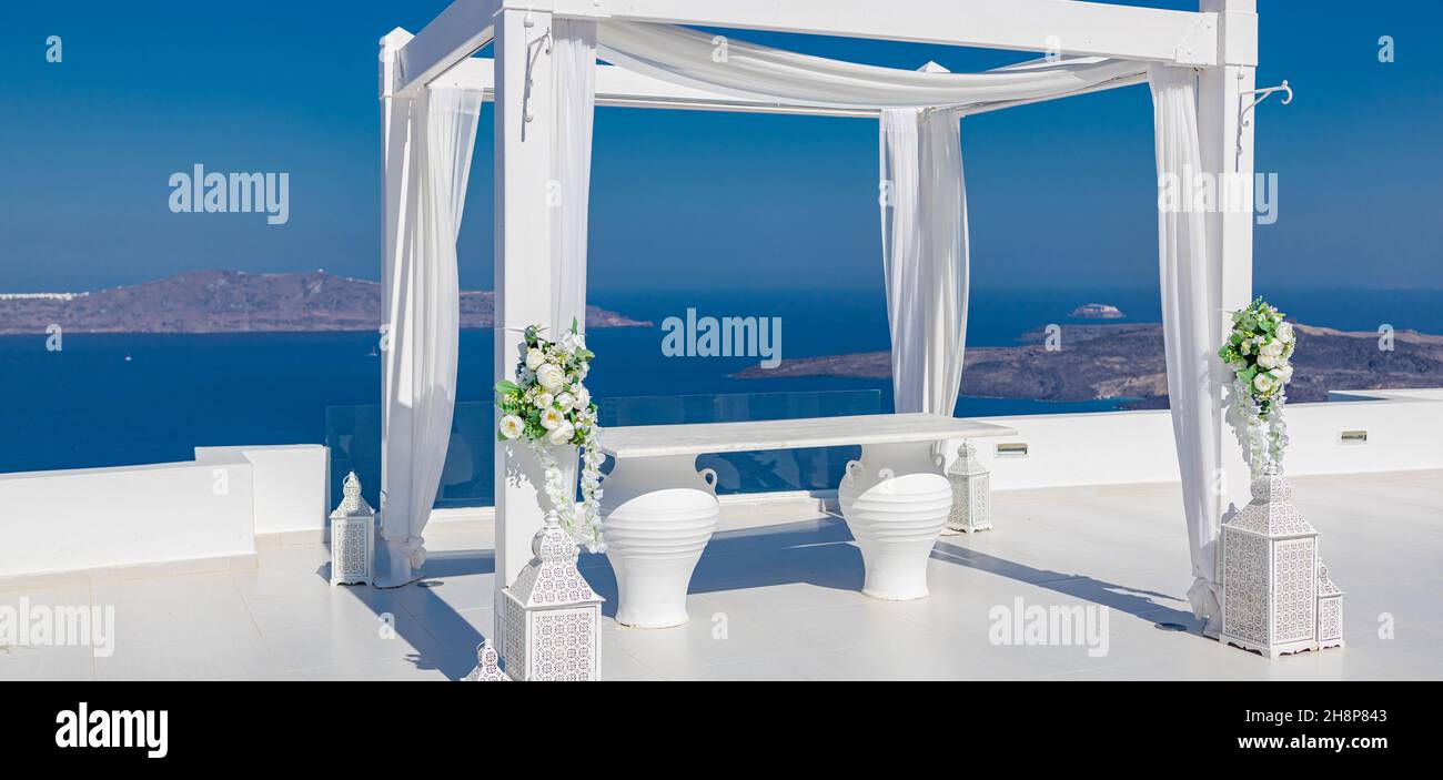 Île de Santorini, Grèce. Décoration de mariage sur une destination populaire de couple. Arc de mariage élégant avec fleurs blanches, vases sur fond de mer bleue Banque D'Images