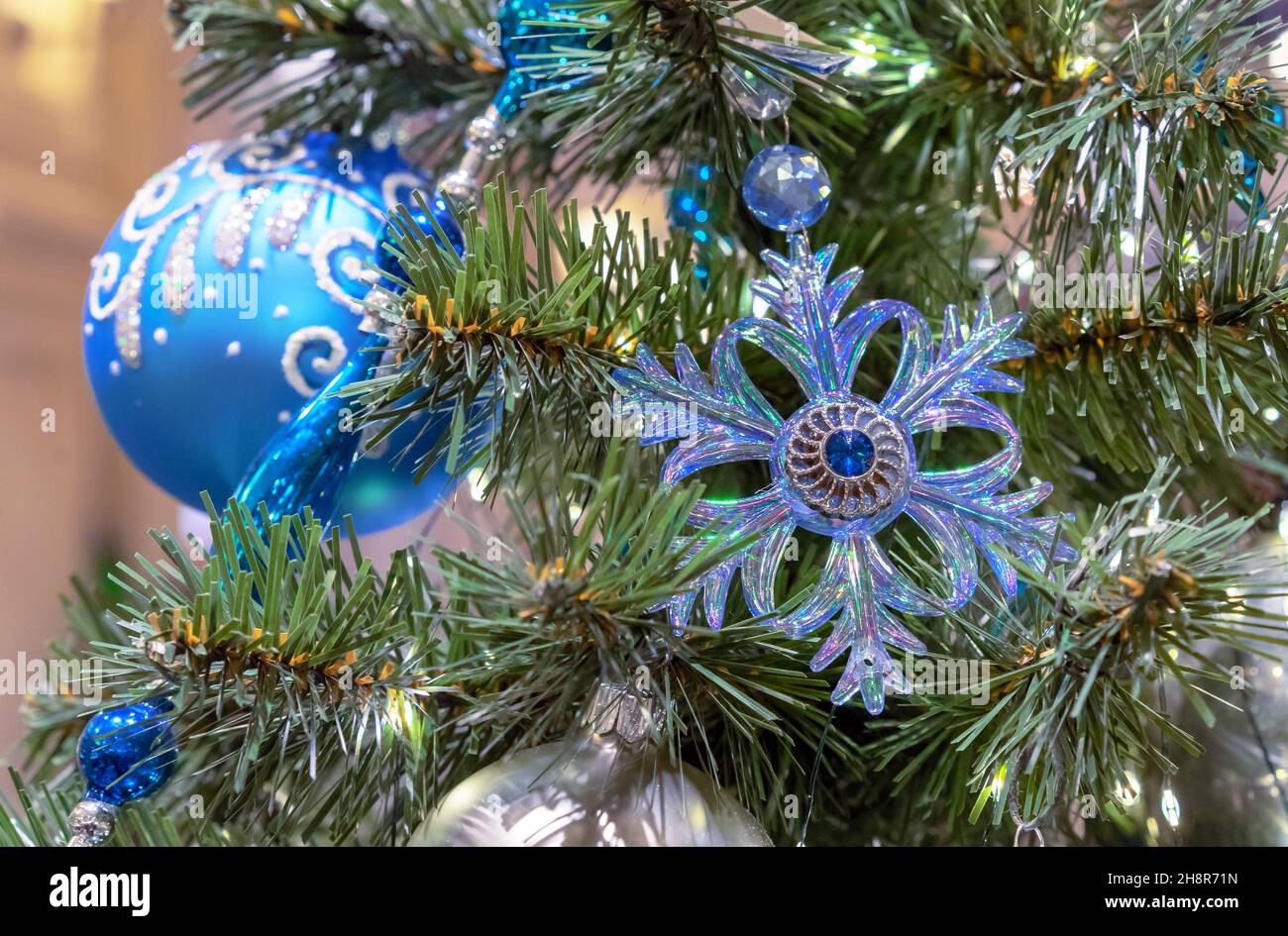 Flocon de neige bleu en verre et boule de Noël bleue avec ornement sur l'arbre de Noël. Banque D'Images