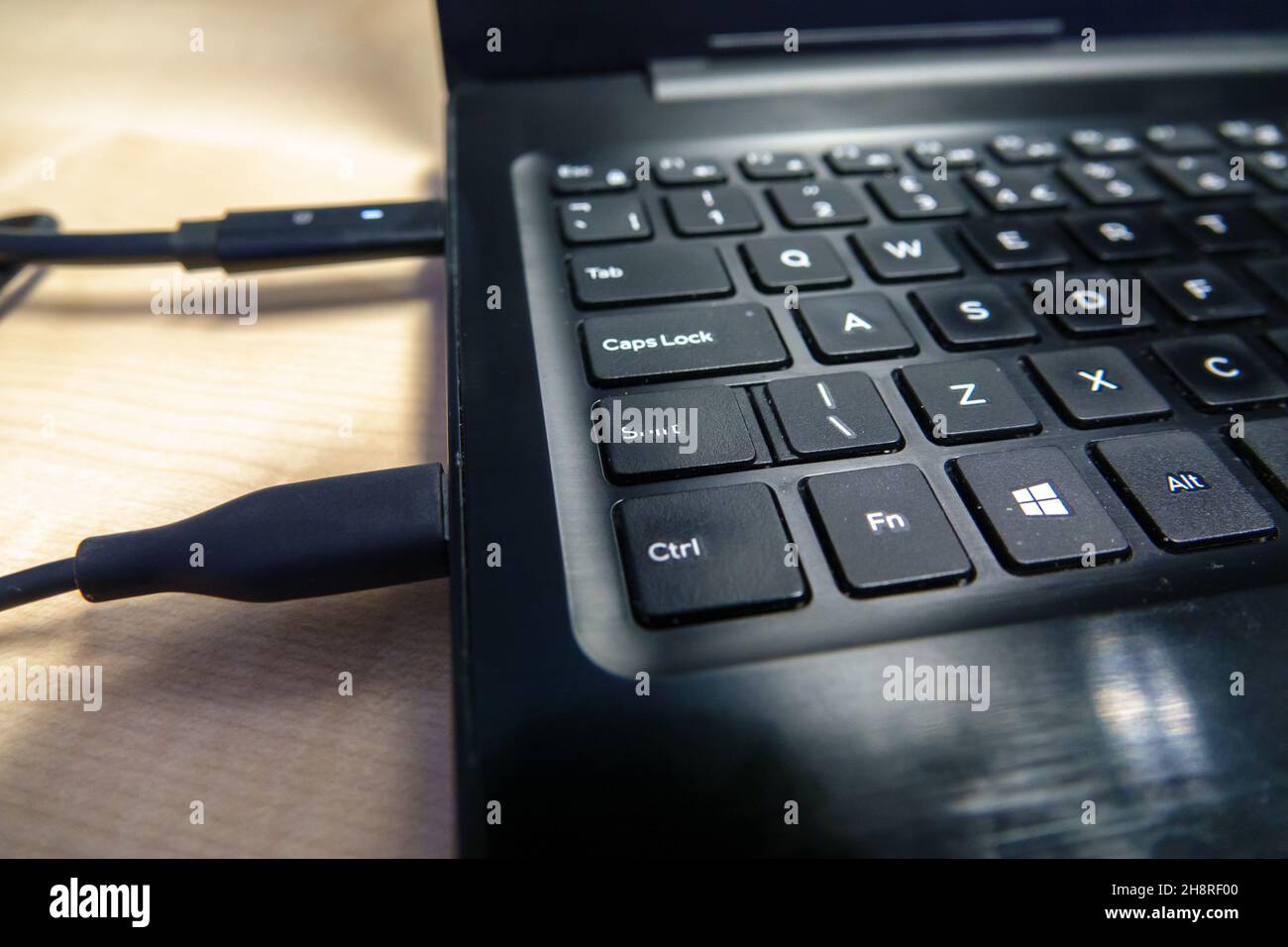 Letf main côté d'une lettre blanche sur clavier noir de fenêtres d'ordinateur portable avec une touche Maj usée Banque D'Images