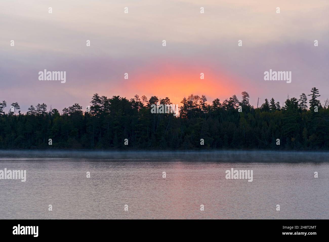 Tôt le matin lueur du soleil dans les nuages sur le lac Sagnaga dans les eaux limitrophes au Minnesota Banque D'Images