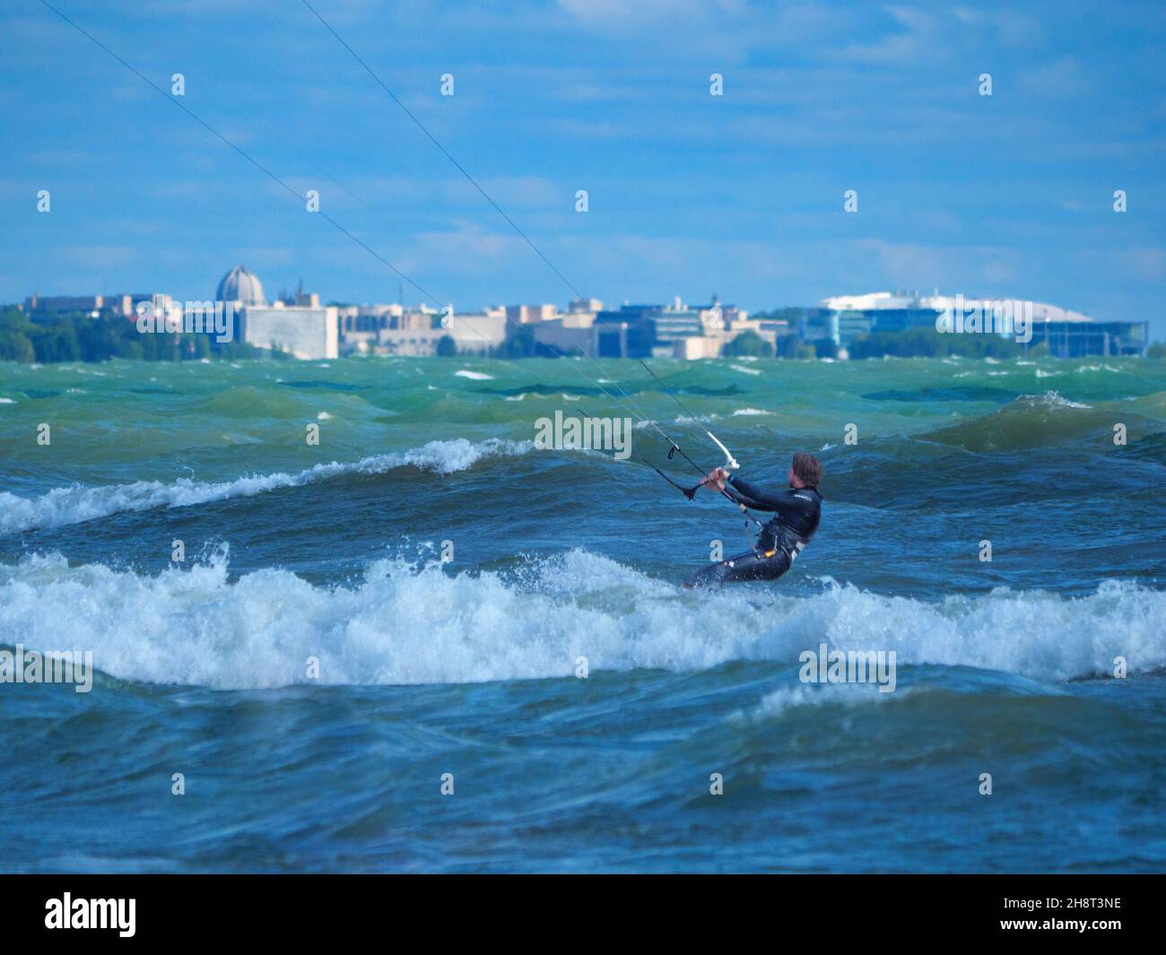 Kite surfer et surfer.Montrose Beach, Chicago, Illinois.Temple Baháʼí et Université Northwestern à distance. Banque D'Images