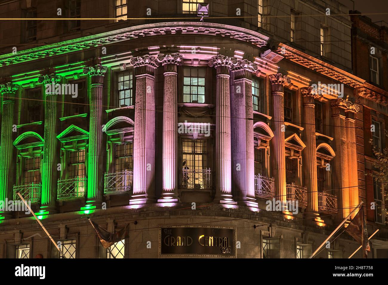 Dublin, Irlande - 13 novembre 2021 : belle vue de soirée des lumières de projection décorations imitant le drapeau irlandais sur la façade du Grand Central Bar. Banque D'Images