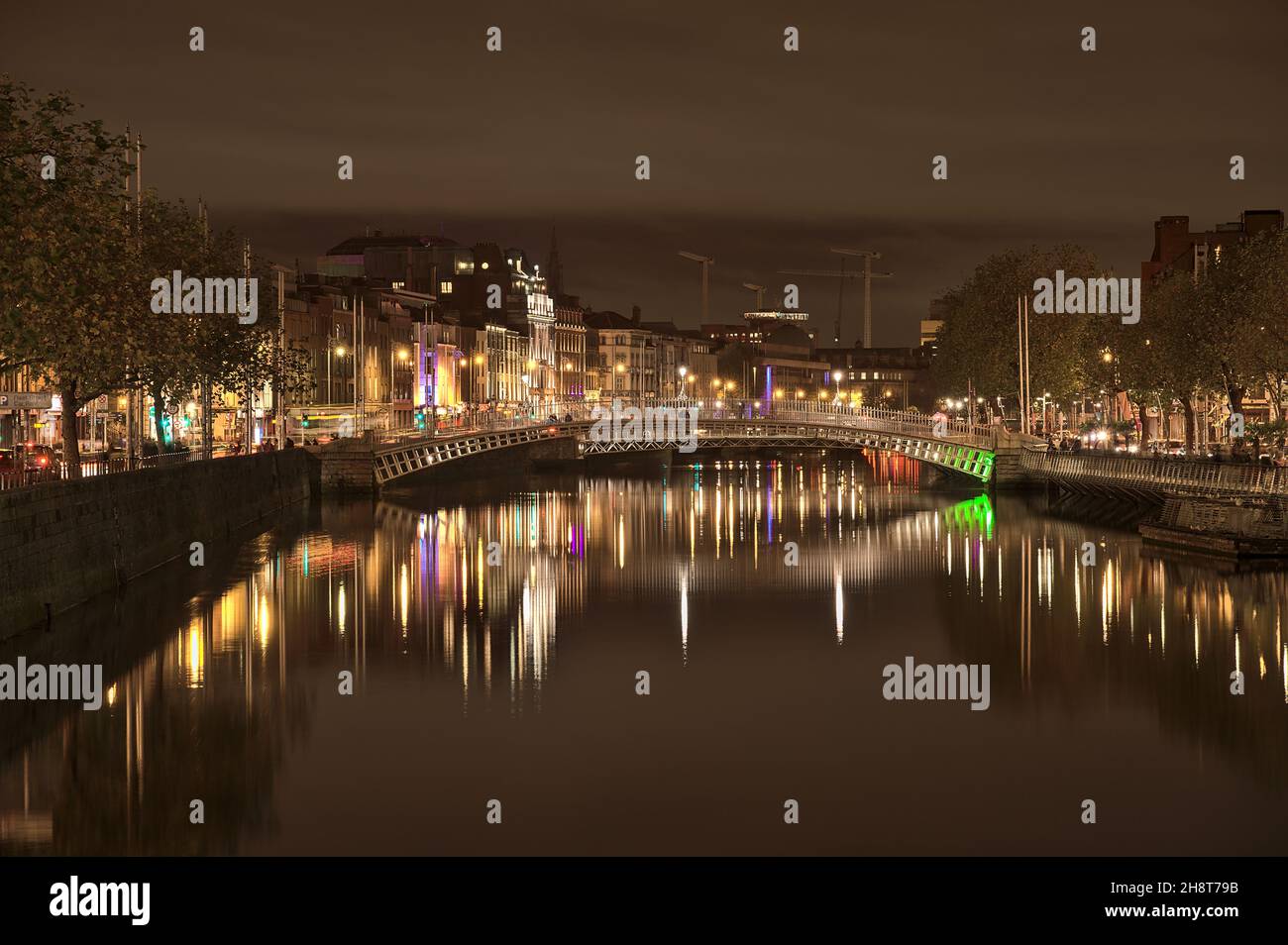Dublin, Irlande - 13 novembre 2021 : magnifique vue en soirée sur la rivière Liffey et le pont éclairé Ha'penny.Rénovation de la plage en fonte du XIXe siècle Banque D'Images