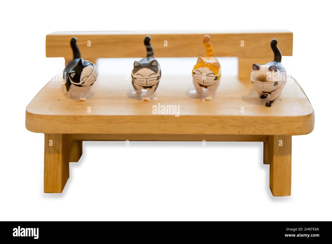 Petit bois de poupée de chat sur le banc en bois, se concentre sélectif sur fond blanc. Banque D'Images