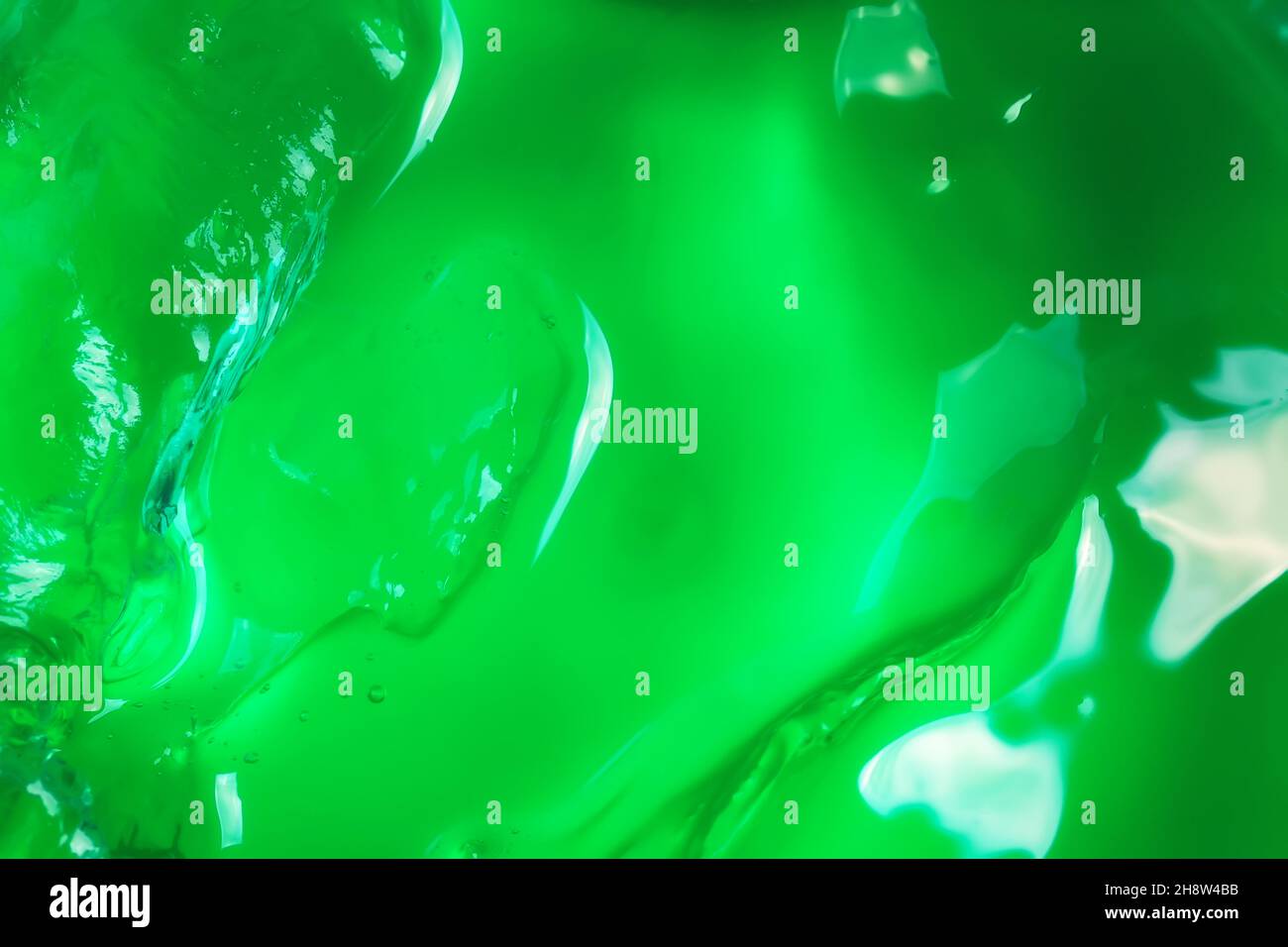 Lotion cosmétique gel fond vert.Concept cosmétique.Gel liquide cosmétique taches texture.Style plat, vue de dessus. Banque D'Images