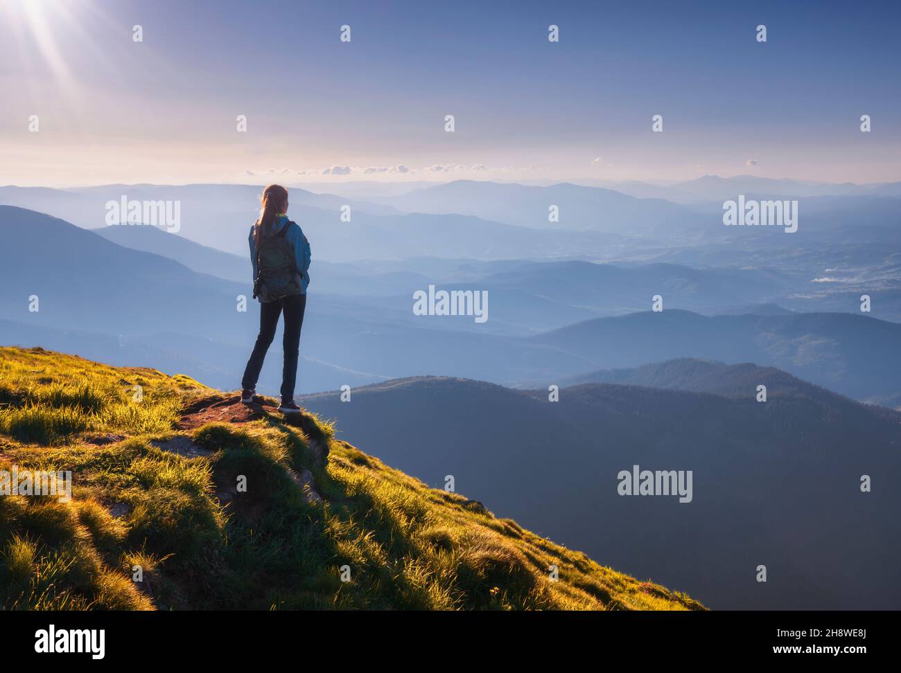 Fille avec sac à dos et belle vallée de montagne dans le brouillard au soleil Banque D'Images