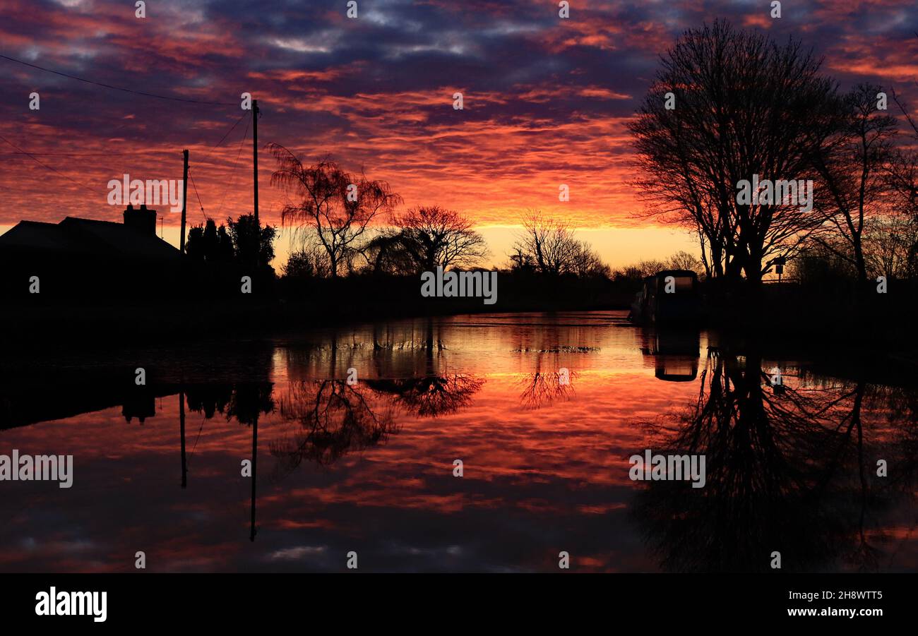 Le soleil brûlant rouge vient de se lever sur un canal froid et glacé de Leeds et Liverpool le matin d'automne près de Crabtree Lane près de Burscough Banque D'Images