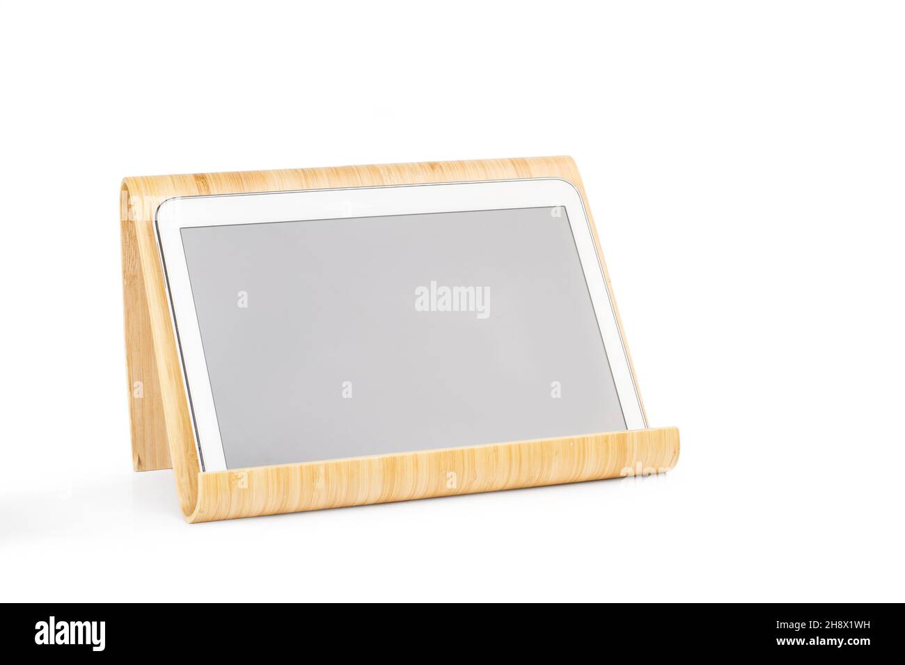 Tablette numérique sur une base en bois de bambou sur fond blanc avec espace de copie Banque D'Images