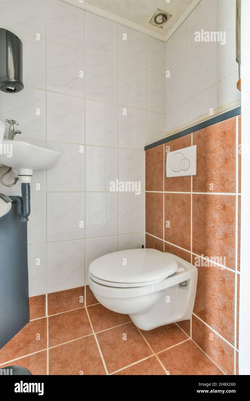 Intérieur contemporain de salle de bains avec cuvette de toilette et lavabo  sur mur de carrelage rouge dans la maison lumineuse Photo Stock - Alamy