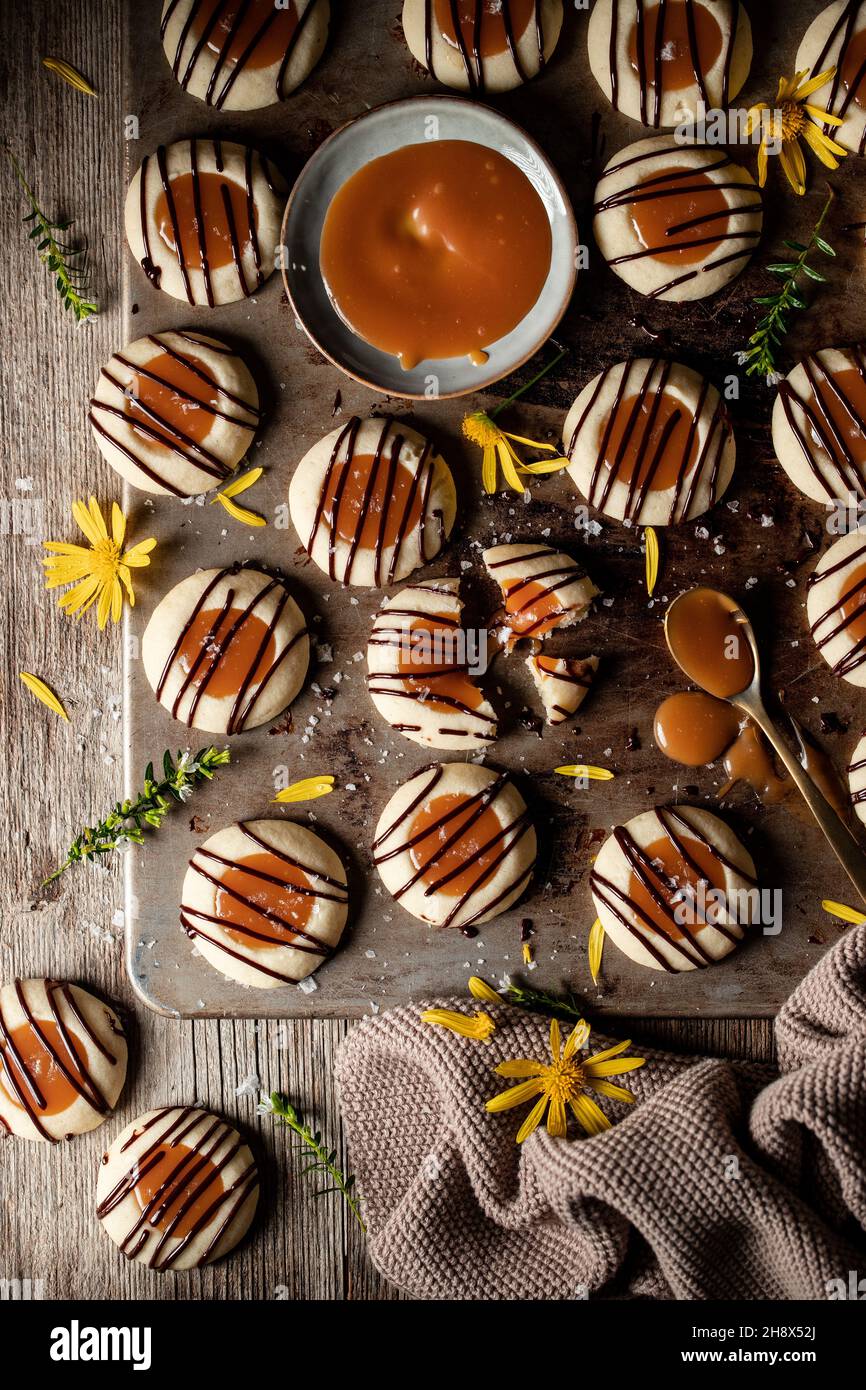 Vue de dessus pile de délicieux petits gâteaux fraîchement cuits avec de la bruine de caramel et de chocolat servi sur une table en bois dans la cuisine légère Banque D'Images