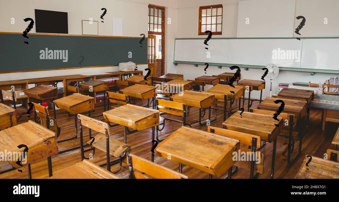 Composite numérique de points d'interrogation noirs sur une salle de classe vide avec des bureaux en bois à l'école Banque D'Images
