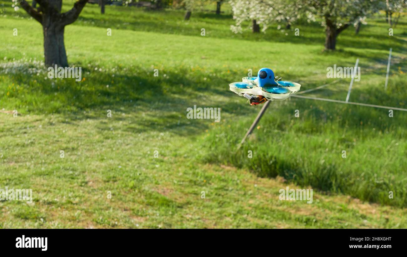 Les petits drones bleus sont contrôlés avec une caméra vidéo sur un champ vert, l'œil noir pointe vers le pilote.Nuertingen, Allemagne Banque D'Images
