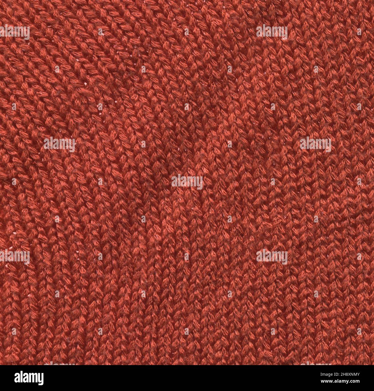 Coudre la texture pourpre du pull en gros plan.Arrière-plan tricoté en tissu rouge texturé. Banque D'Images