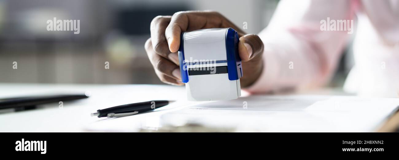 African American Black Man utilisant le timbre de notaire sur le papier officiel Banque D'Images
