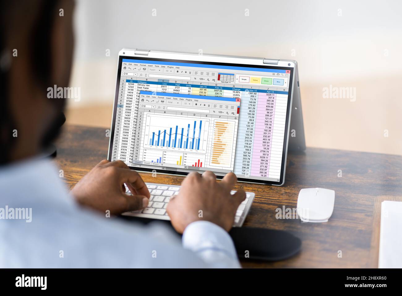 Analyste financier utilisant un logiciel de feuille de calcul sur un ordinateur de bureau Banque D'Images