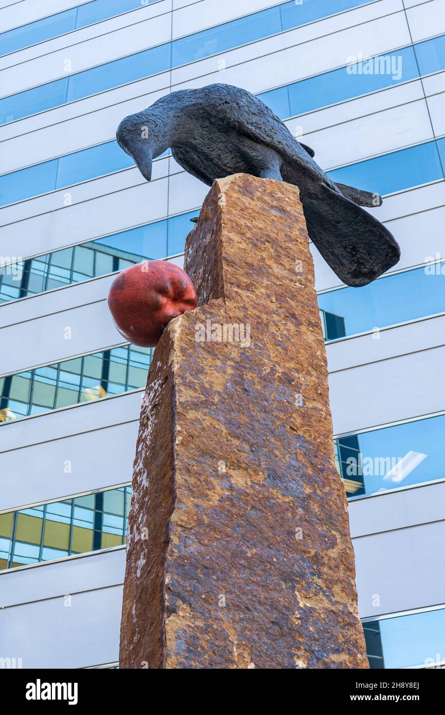 Oklahoma City, OK - 17 septembre 2021 : une sculpture d'un Corbeau et d'une pomme par l'artiste Peter Woytuk se trouve devant une tour d'entreprise. Banque D'Images