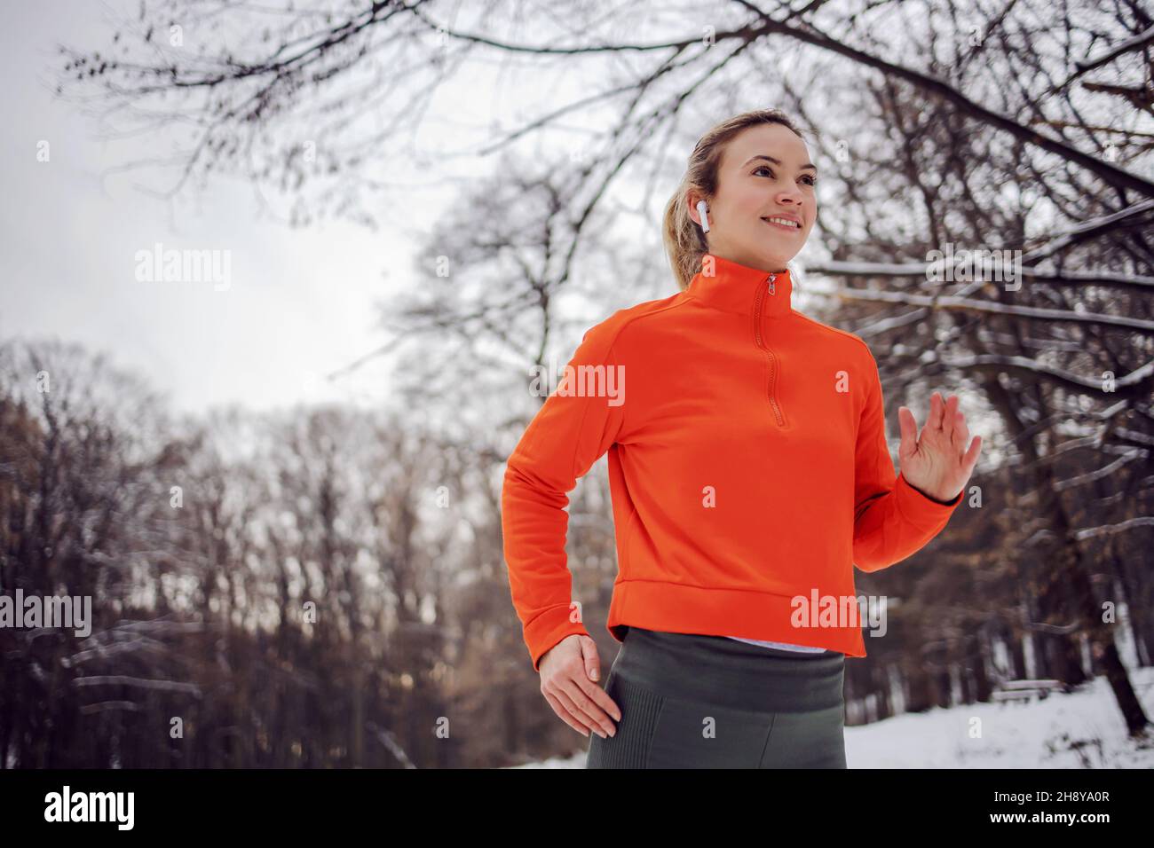 FIT sportswoman courir dans la nature lors d'une journée d'hiver enneigée.Temps froid, neige, vie saine, fitness, forêt Banque D'Images
