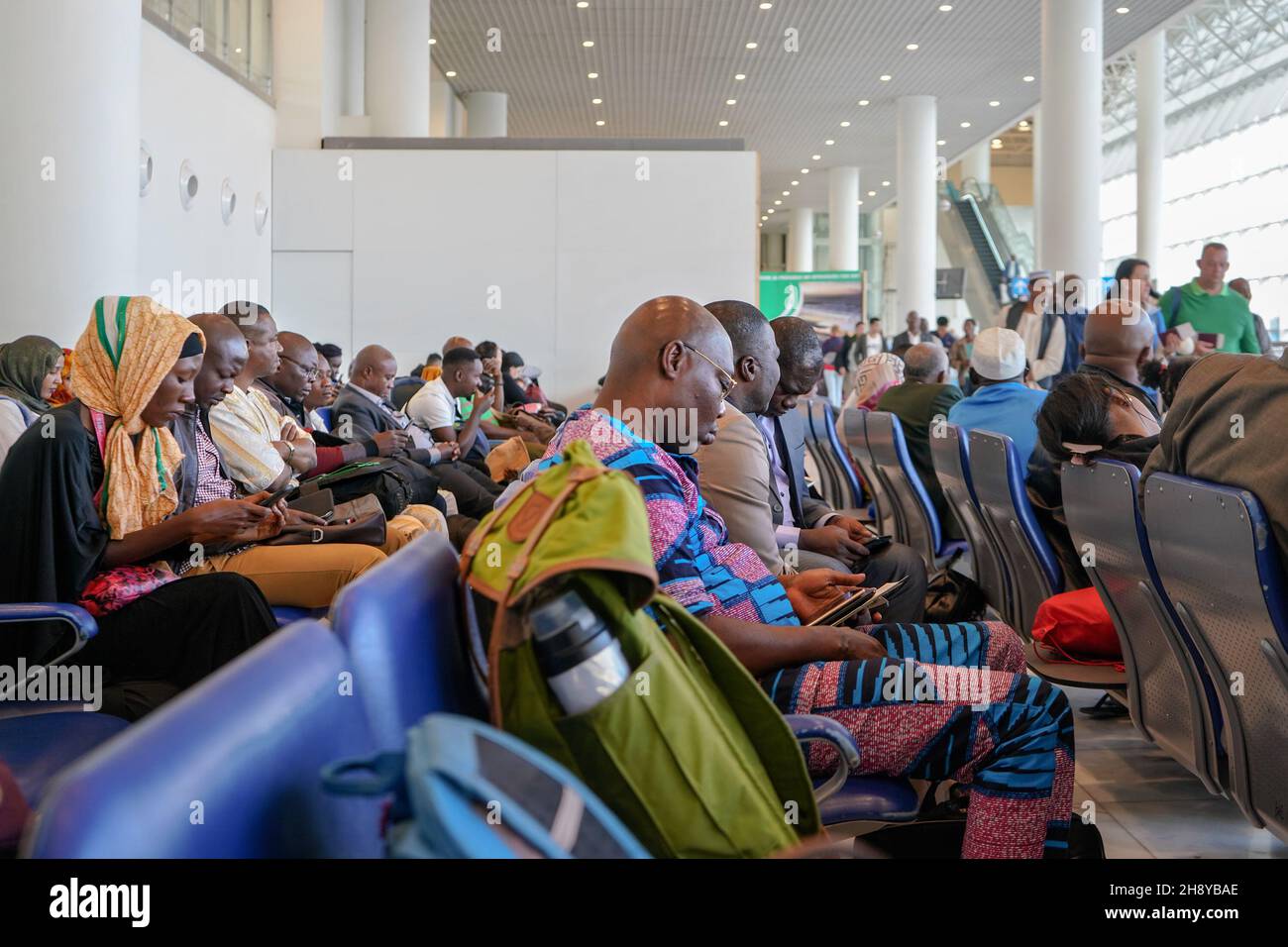 Addis-Abeba, Éthiopie - 23 avril 2019 : passagers locaux qui vérifient leurs téléphones et leurs tablettes en attendant dans le hall des départs de l'aéroport international de Bole Banque D'Images