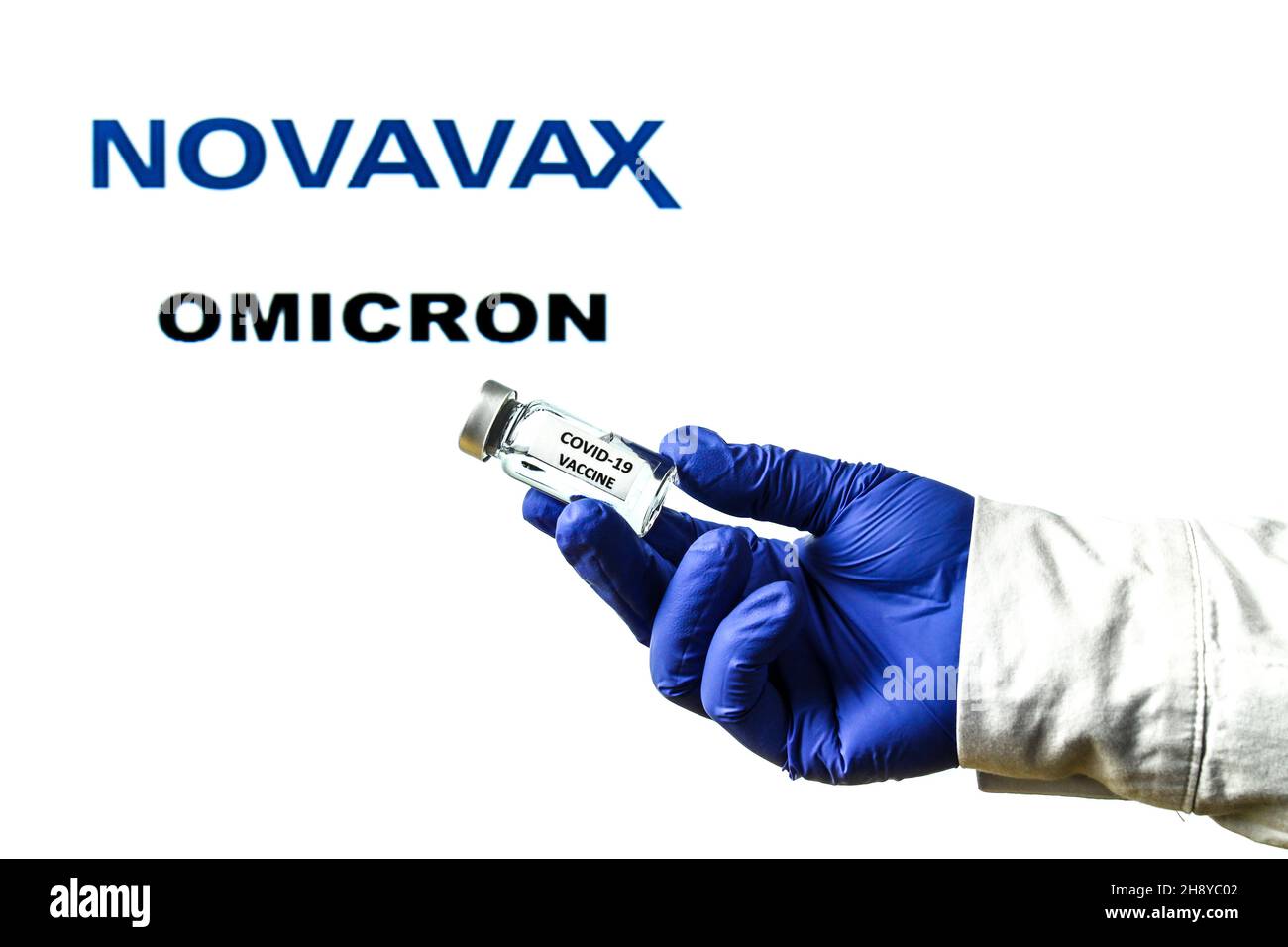 Madrid, Espagne - 29 novembre 2021 : flacon à main avec vaccin contre le covid.Logo Novavax et Omicron covid variante mot écrit en arrière-plan Banque D'Images