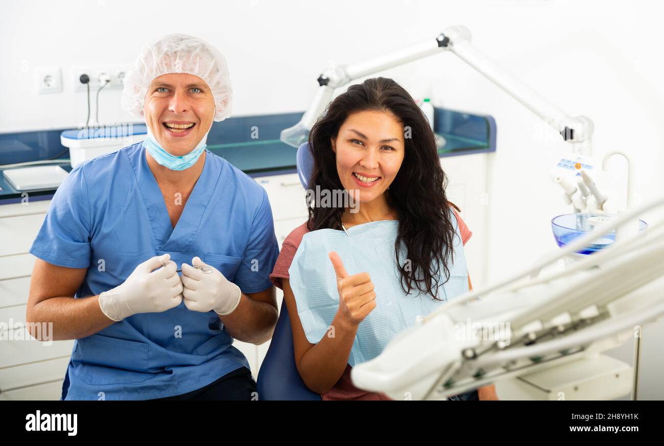 Portrait d'un dentiste souriant qualifié avec une patiente satisfaite Banque D'Images