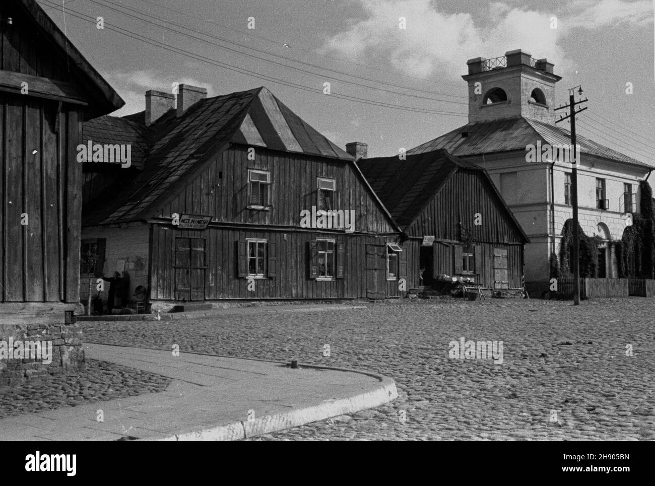 Mogielnica, 1947.Rynek z klasycystycznym ratuszem z pierwszej po³owy XIX w. i drewnianymi domami.W domu z dachem naczó³kowym sklep miêsny Mieczys³awa Koz³owskiego.Na rynku bruk kamienny tzw. Kocie ³by. bb/gr PAP Dok³adny miesi¹c i dzieñ wydarzenia nieustalone.Mogielnica, 1947.Le marché pavé.L'hôtel de ville datant de la 1ère moitié du 19ème siècle et des maisons en bois.Mieczyslaw Kozlowski, magasin de viande près de l'hôtel de ville. bb/gr PAP Banque D'Images