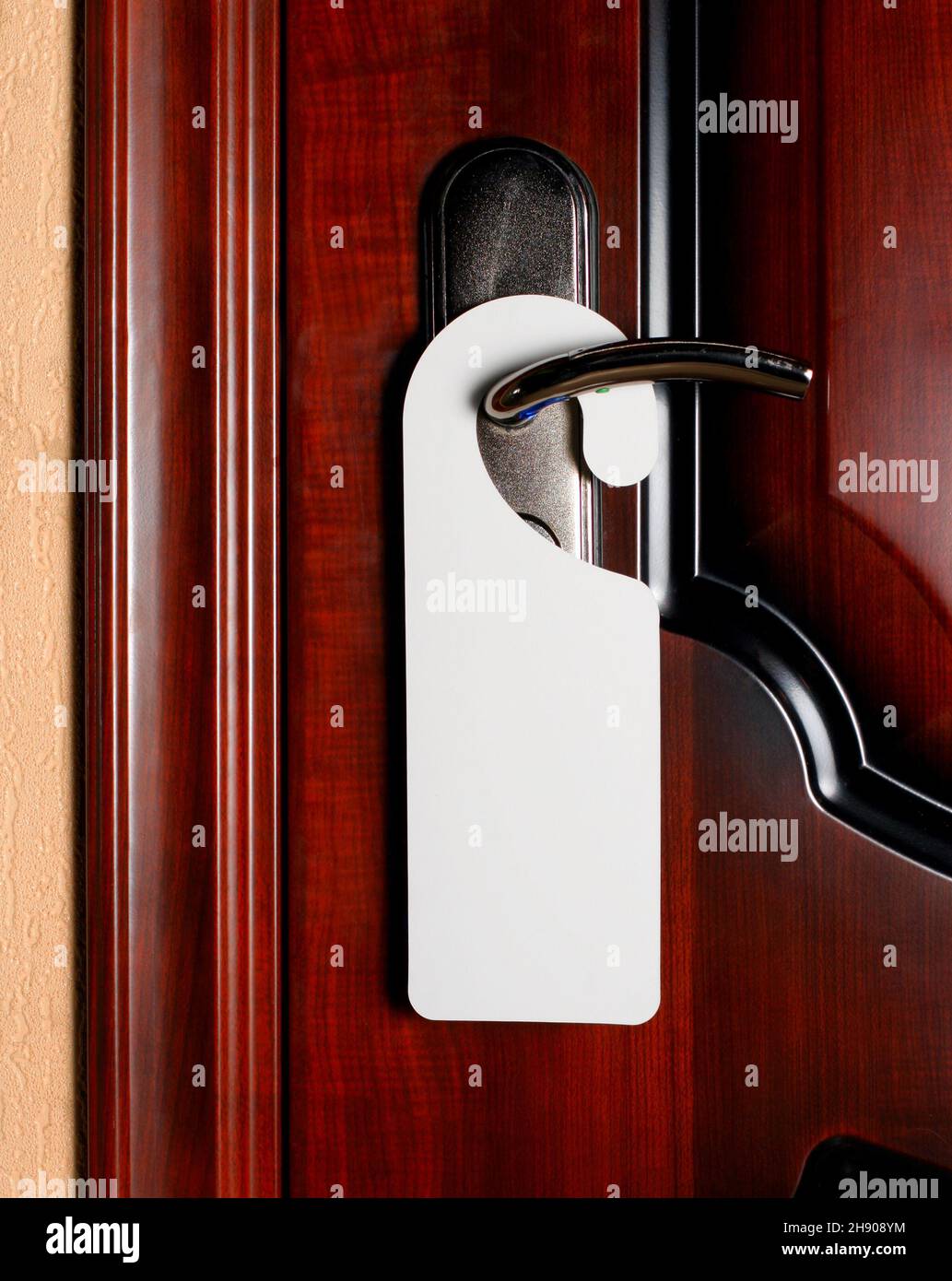 Bouton de porte avec étiquette vide sur une poignée de porte pour votre  texte. Maquette flyer blanche vide accrocher sur la poignée de la porte.  Notice sur la poignée d'entrée de conception.